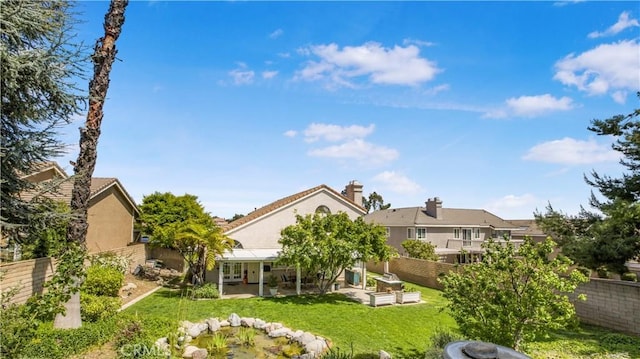 back of property with a patio, a fenced backyard, a lawn, stucco siding, and french doors