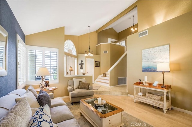 living room featuring wood finished floors, visible vents, stairs, and baseboards