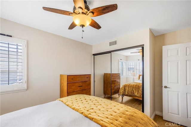 bedroom with visible vents, a ceiling fan, and a closet