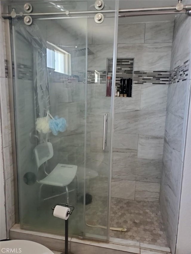 bathroom with a shower stall and toilet
