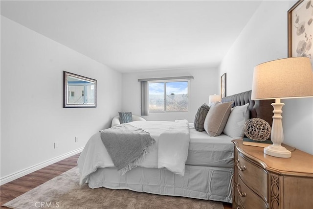 bedroom with wood finished floors and baseboards
