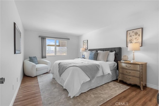 bedroom with baseboards and wood finished floors