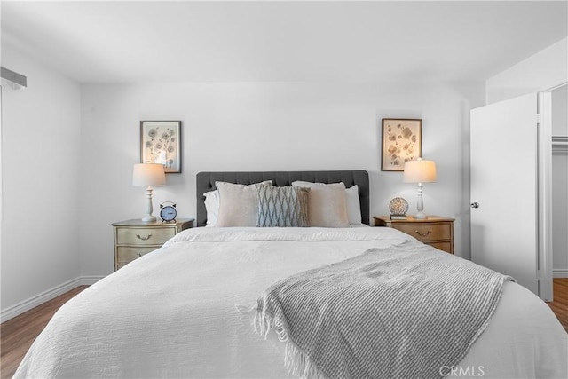 bedroom with wood finished floors and baseboards