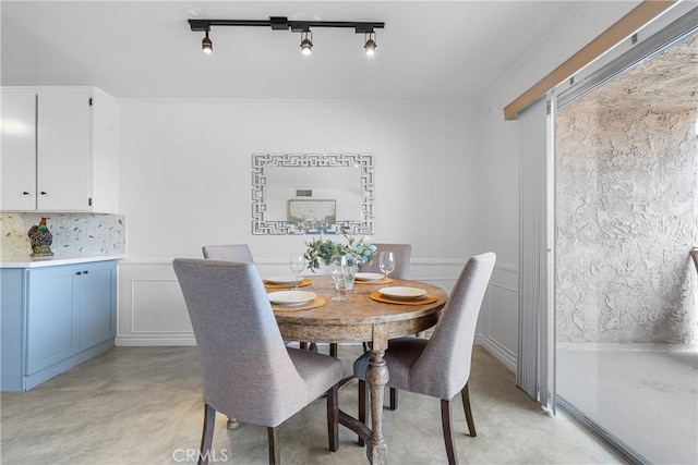 dining area featuring track lighting and ornamental molding