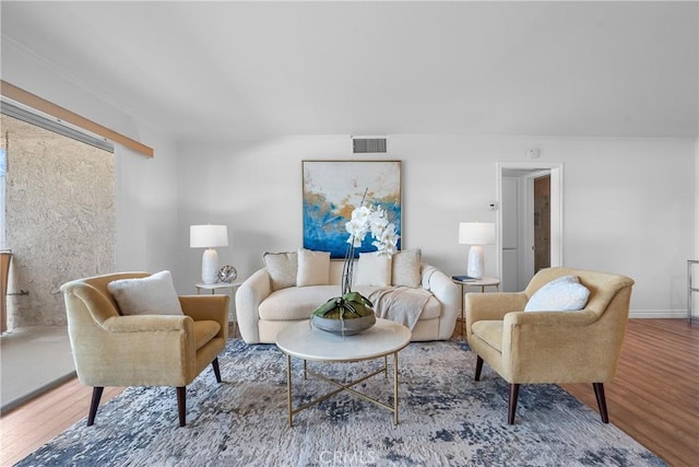 living room with visible vents, wood finished floors, and baseboards