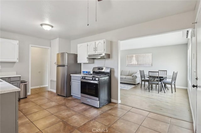 kitchen with white cabinetry, stainless steel appliances, under cabinet range hood, and light countertops
