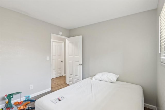 bedroom featuring wood finished floors and baseboards