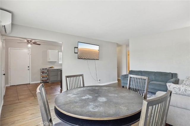 dining space featuring light wood-style flooring, ceiling fan, an AC wall unit, and baseboards