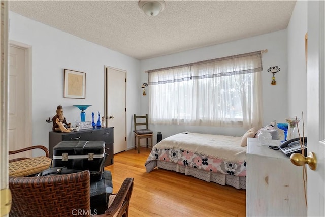 bedroom featuring light wood-type flooring and a textured ceiling