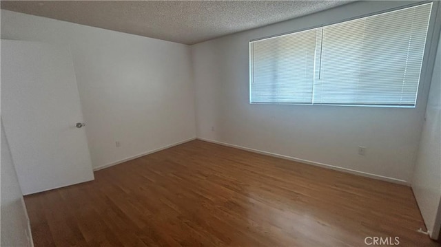 1224 Mohave Dr, Colton, CA 92324 - unfurnished room featuring a textured ceiling, wood finished floors, and baseboards