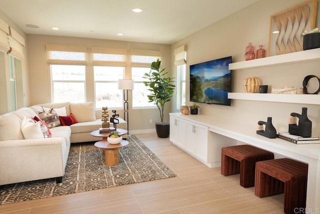 living room with recessed lighting, baseboards, and light wood-type flooring