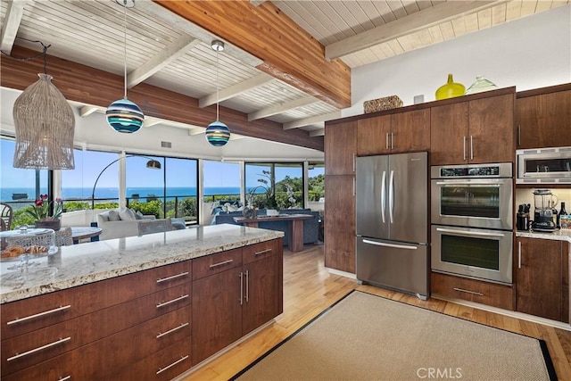 31588 Table Rock Dr, Laguna Beach, CA 92651 - kitchen with stainless steel appliances, light wood finished floors, light stone countertops, dark brown cabinets, and pendant lighting