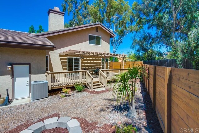 1023 Mimosa Ave, Vista, CA 92081 - rear view of house featuring a pergola, a deck, a chimney, a fenced backyard, and stucco siding
