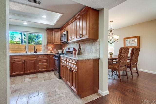 1023 Mimosa Ave, Vista, CA 92081 - kitchen with stainless steel appliances, brown cabinetry, a tray ceiling, and recessed lighting