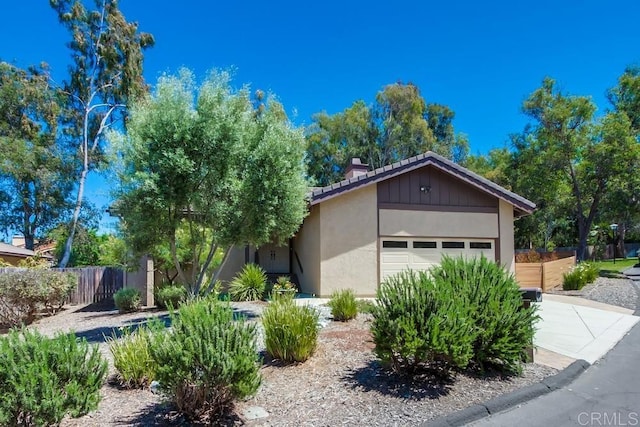 1023 Mimosa Ave, Vista, CA 92081 - view of front facade featuring a garage, a chimney, and stucco siding