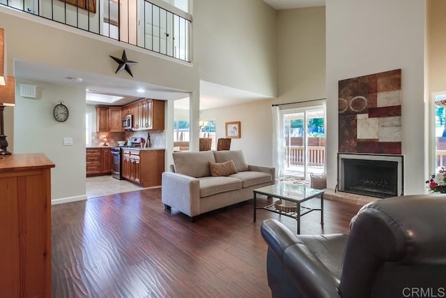1023 Mimosa Ave, Vista, CA 92081 - living room featuring wood finished floors, a high ceiling, and a tiled fireplace