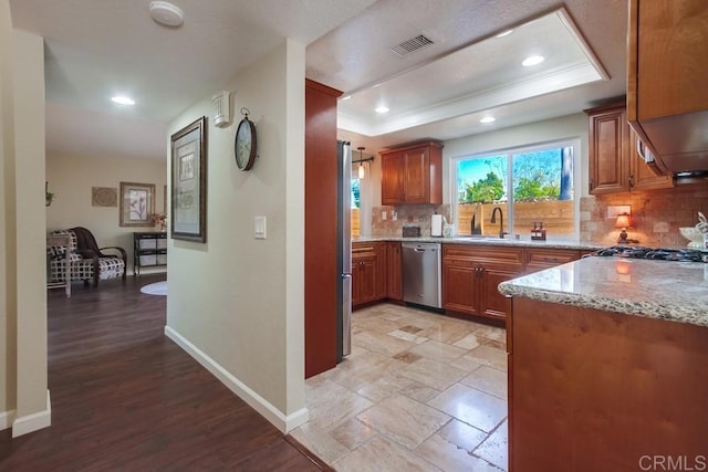 1023 Mimosa Ave, Vista, CA 92081 - kitchen with appliances with stainless steel finishes, tasteful backsplash, light stone counters, brown cabinetry, and a raised ceiling