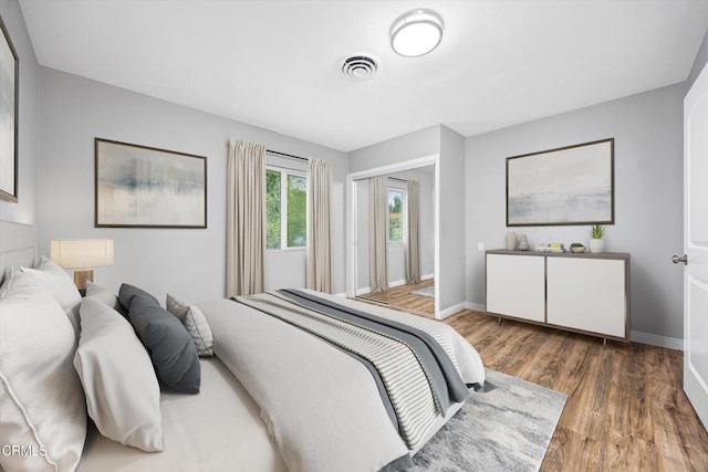 bedroom featuring wood finished floors, visible vents, and baseboards