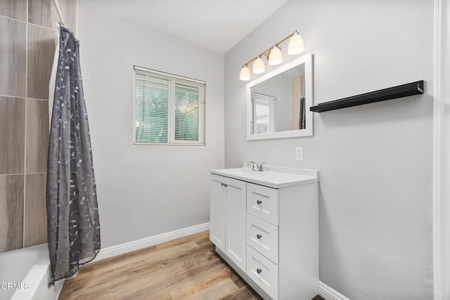 bathroom with wood finished floors, vanity, and baseboards