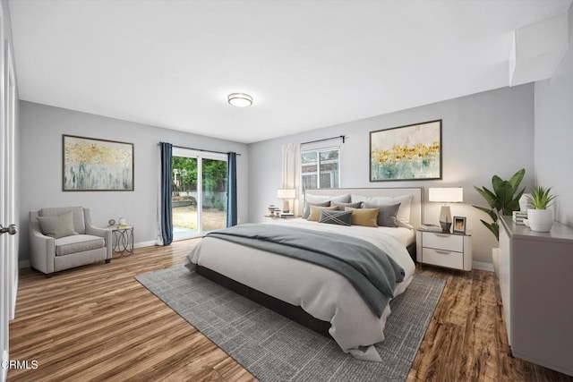 bedroom with access to outside, wood finished floors, and baseboards