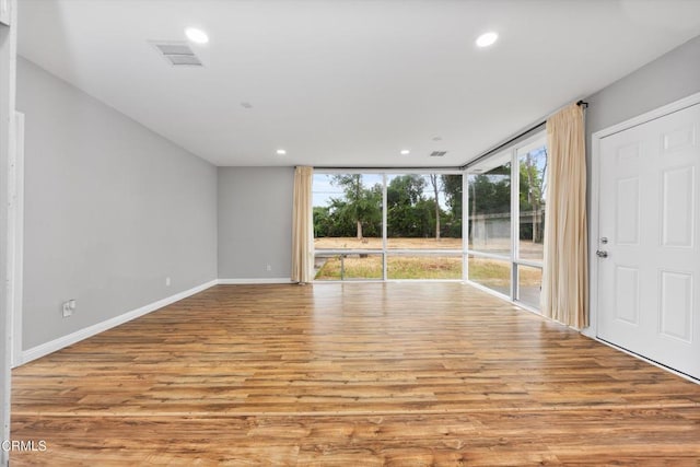 empty room with recessed lighting, visible vents, and wood finished floors
