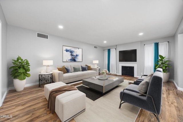 living area featuring baseboards, visible vents, and light wood-type flooring