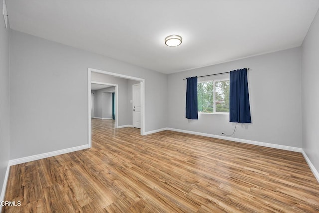 spare room featuring light wood-style flooring and baseboards