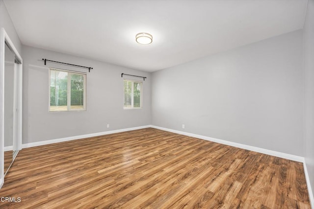 spare room featuring baseboards and wood finished floors