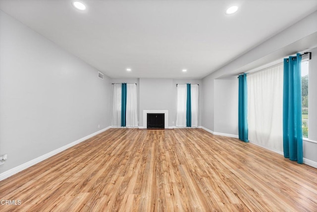 unfurnished living room featuring a fireplace, visible vents, recessed lighting, and baseboards