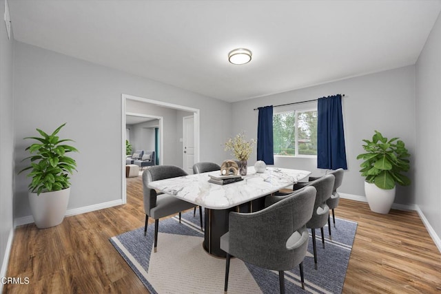 dining area featuring baseboards and wood finished floors