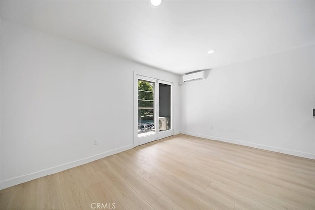 unfurnished room featuring baseboards, light wood-type flooring, recessed lighting, and an AC wall unit
