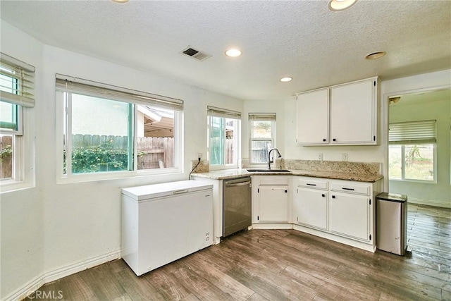 kitchen with visible vents, a sink, white cabinetry, and dark wood-type flooring
