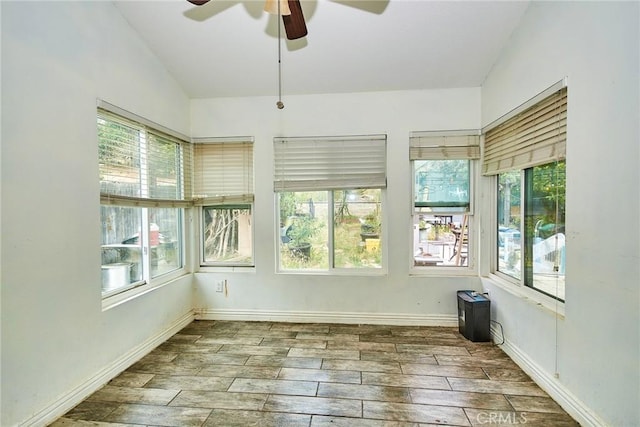 unfurnished sunroom featuring baseboards, wood finished floors, and a wealth of natural light