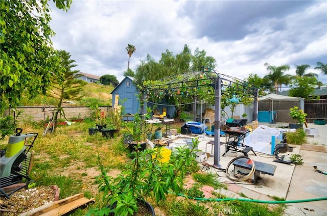 view of yard featuring a gazebo, a storage shed, a fenced backyard, an outbuilding, and a patio