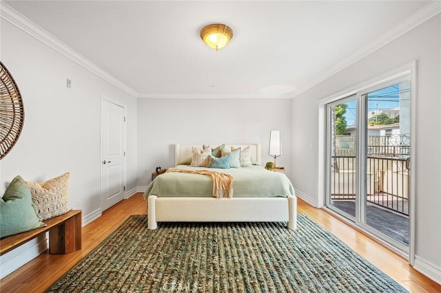 bedroom with baseboards, access to exterior, light wood-style floors, and crown molding