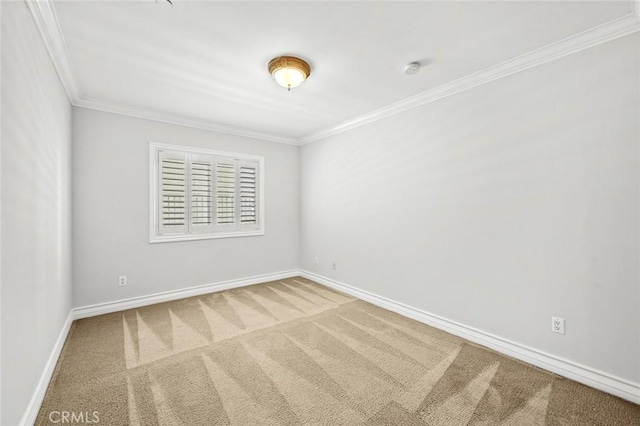 carpeted empty room featuring crown molding and baseboards