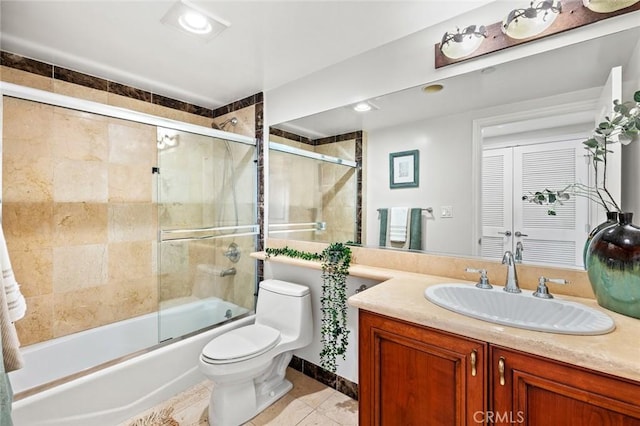 bathroom featuring combined bath / shower with glass door, vanity, toilet, and baseboards