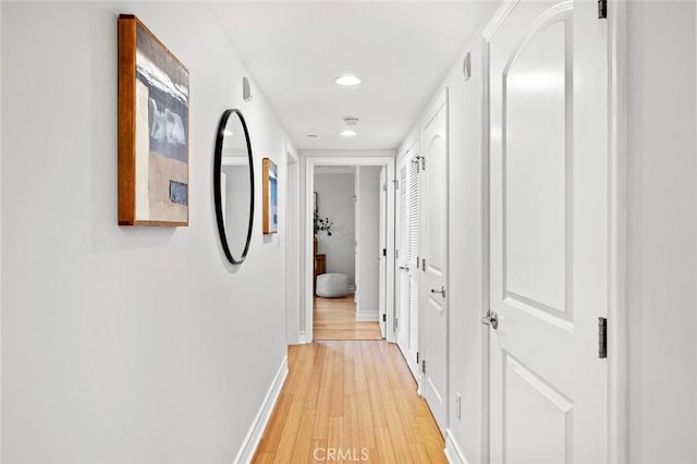 hall with baseboards, recessed lighting, and light wood-style flooring