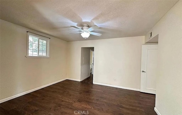empty room with a textured ceiling, a ceiling fan, and dark wood finished floors