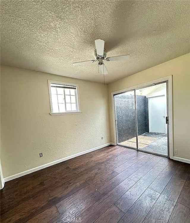 unfurnished room featuring baseboards, a ceiling fan, a textured ceiling, and dark wood-type flooring