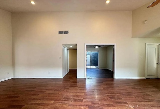 spare room featuring visible vents, ceiling fan, and a towering ceiling