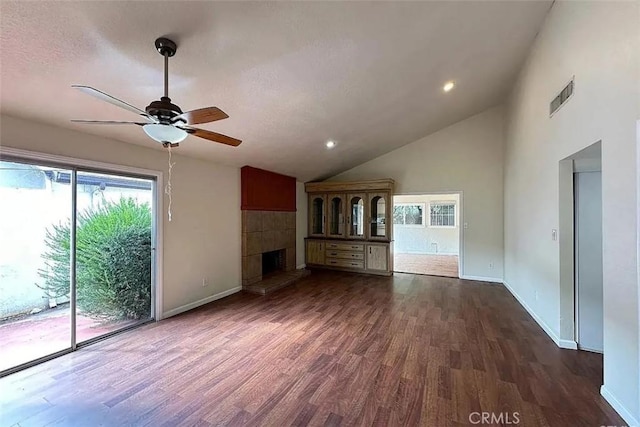 unfurnished living room featuring dark wood-type flooring, a ceiling fan, visible vents, baseboards, and lofted ceiling