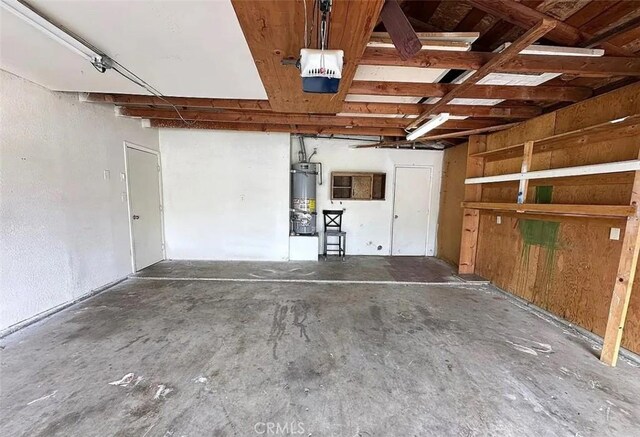 garage with strapped water heater and a garage door opener