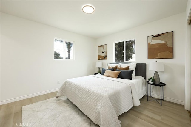 bedroom with wood finished floors and baseboards