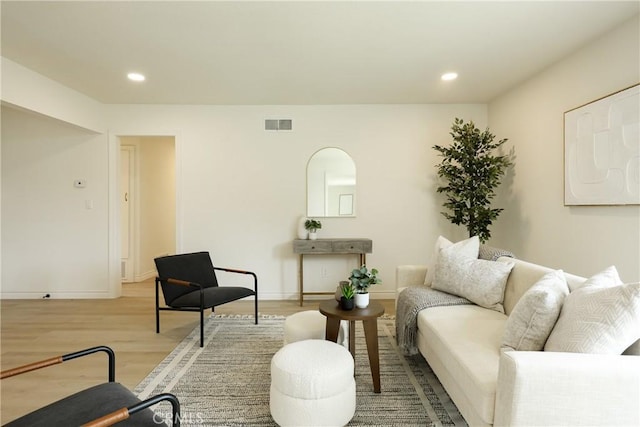 living area with baseboards, visible vents, wood finished floors, and recessed lighting