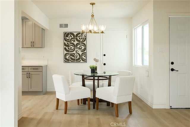 dining room featuring a chandelier, visible vents, a wealth of natural light, and light wood-style flooring