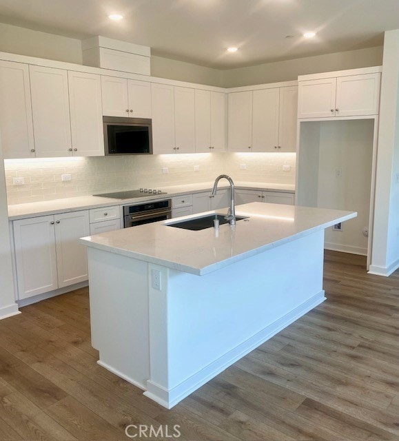 kitchen featuring a sink, white cabinets, dark wood-style flooring, and oven