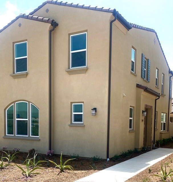 view of home's exterior with stucco siding and a tile roof