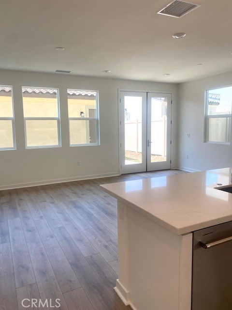 interior space with visible vents, french doors, hardwood / wood-style flooring, and baseboards