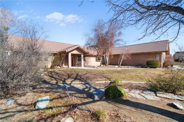 ranch-style house with stucco siding and a tiled roof